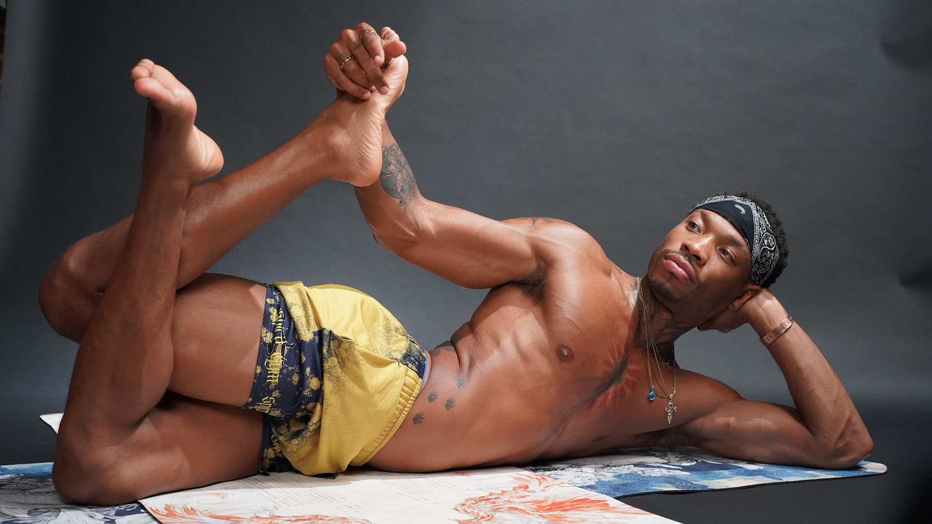 Ari in a reclined yoga pose on a printed mat